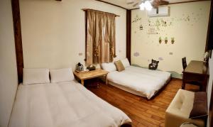 a room with two beds and a table and a couch at Share B&B in Puli