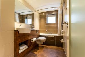 a bathroom with a toilet and a sink and a mirror at Holiday Inn Newcastle-Jesmond, an IHG Hotel in Newcastle upon Tyne