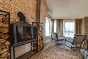 a living room with a fireplace and a brick wall at The Berg's 1 in Ocna-Mureşului