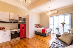 een keuken met een bed en een rode koelkast in een kamer bij Vesper Apartments in Kaapstad