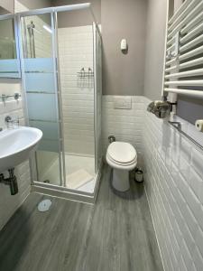 a bathroom with a toilet and a glass shower at Arie Romane Guesthouse in Rome