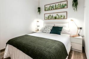 1 dormitorio con 1 cama con manta verde en Tresor Boutique Apartment, en Girona