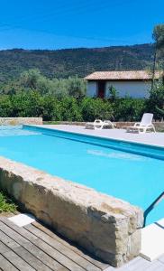 ein großer blauer Pool mit Stühlen und ein Haus in der Unterkunft Agricontura in Capri Leone