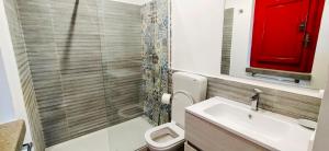 a bathroom with a toilet and a sink and a red window at Agricontura in Capri Leone