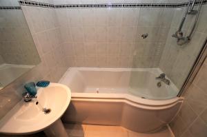 une salle de bain avec une baignoire et un lavabo et une baignoire dans l'établissement Freeland Cottage, à Dunoon 16 autres photos