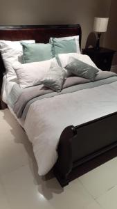 a large bed with many pillows on it at The Sails in Durban +15 photos