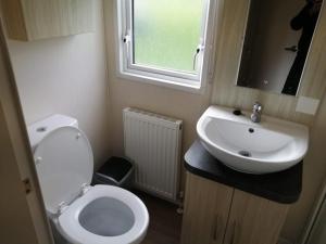 a small bathroom with a toilet and a sink at 67 Newquay Getaway in Porth +14 photos