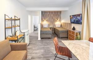 ein Hotelzimmer mit 2 Betten und einem Sofa in der Unterkunft Excellentas Apartments Hannover in Hannover