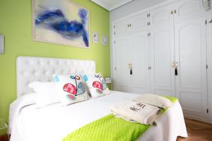 sypialnia z białym łóżkiem i zielonymi ścianami w obiekcie Milla De Oro w Madrycie