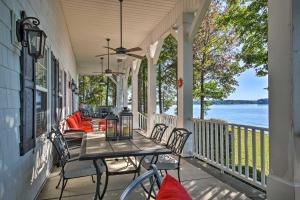 a porch with a table and chairs and a view of the water at Lakefront Paradise with Fire Pit - Dogs Welcome! in Chappells
