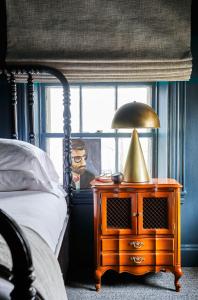 Blind Tiger Portland - Danforth Street في بورتلاند: غرفة نوم بسرير وطاولة مع مصباح