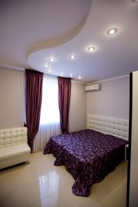 1 dormitorio con cama morada y ventana en Apartments Near The Airport, en Adler