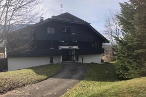 een groot zwart-wit huis met een oprit bij Studio entièrement rénové entre lac et montagne in Thollon