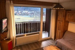 Il comprend un salon doté d'une grande fenêtre et d'un balcon. dans l'établissement Studio agréable et cosy avec vue sur les Mémises, à Thollon-les-Mémises