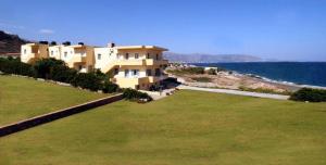 a large building next to a large field of grass at Nautilus Apartments in Sissi