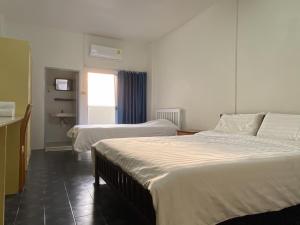 um quarto de hotel com duas camas e uma janela em Monta Apartment em Bangsaen