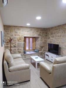 sala de estar con 2 sofás y TV en Apartamentos Alameda, en Sigüenza