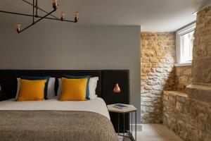 a bedroom with a bed with yellow and blue pillows at Hotel Indigo - Bath by IHG in Bath