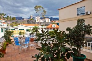 a patio with chairs and tables on a balcony at Residencial Colombo in Funchal