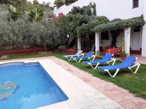 a pool with lounge chairs and a house at Casa del Lavadero in Montecorto