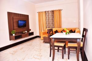 a living room with a dining table and a television at Yellow Leaf in Rishīkesh