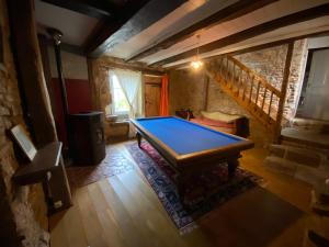 a ping pong table in a room with a staircase at Spacieuse ferme rénovée fin 18ième s. classée 3* in Arpenans