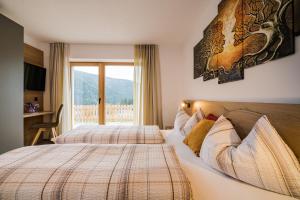 a bedroom with two beds and a window at Appartement Förra in Valle Di Casies