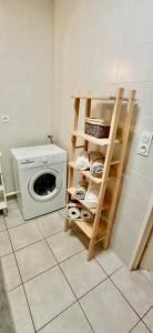 a laundry room with a washing machine and a shelf at Brit's Studio in Talange