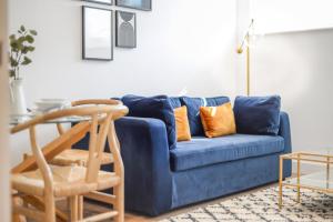 a blue couch with orange pillows in a living room at Concorde House Luxury Apartments - Chester in Chester