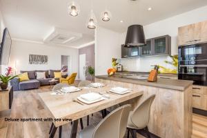 cocina y sala de estar con mesa y sillas en Apartments Liana, en Opatija
