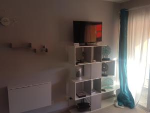 a living room with a tv on a white shelf at PLAYA LAS VISTAS LOFT in Los Cristianos