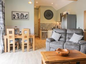 a living room with a couch and a table at The Old Byre in Jedburgh