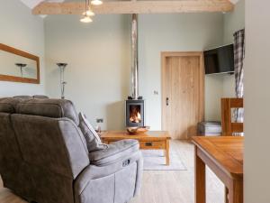 a living room with a couch and a fireplace at The Old Byre in Jedburgh