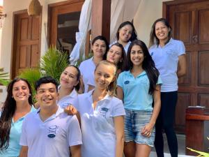 um grupo de pessoas em camisas brancas posando para uma foto em Pousada Tartaruga em Pipa