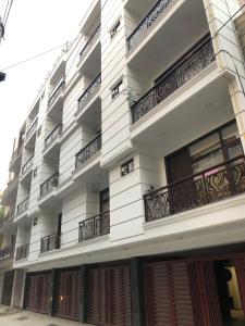 ein weißes Gebäude mit Balkon auf der Seite in der Unterkunft Lemon Green Residency - Hotel and Serviced Apartments in Neu-Delhi