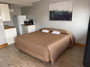 een slaapkamer met een bed met twee handdoeken erop bij Caribou Lodge and Motel in Soda Springs