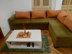 Nika Apartment في بلغراد: غرفة معيشة مع أريكة وطاولة