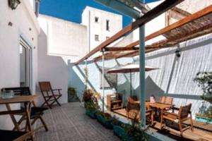 balcón con mesa, sillas y sombrilla en Blue Vintage House, en Setúbal
