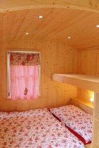 ein Schlafzimmer mit einem Bett in einer Holzhütte in der Unterkunft Zirkuswagen in Holzminden