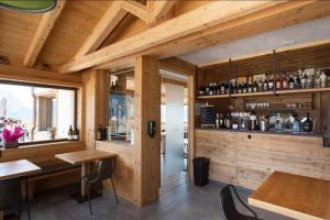 a room with a bar with wooden walls and tables at Locanda La Baita in Santo Stefano di Cadore
