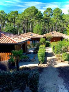 un grupo de edificios con árboles en el fondo en Domaine du Ferret Restaurant & Spa, en Cap-Ferret