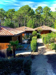 a group of buildings with trees in the background at Domaine du Ferret Restaurant & Spa in Cap-Ferret +37 photos