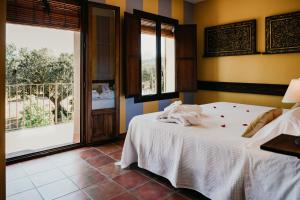 a bedroom with a bed and a large window at Casa Rural Alcornocalejo in Monesterio