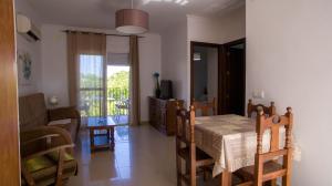 a dining room with a table and a living room at Apartamentos Conil Alquila in Conil de la Frontera
