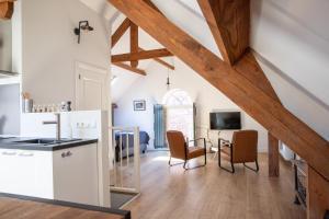 a kitchen and living room with wooden ceilings at Bed & Breakfast Monument076 Etten-Leur in Etten-Leur