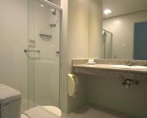a bathroom with a toilet and a sink and a shower at Xingó Parque Hotel in Canindé de São Francisco