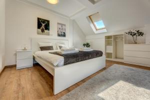Apartment Grey Mountain في زلاتيبور: غرفة نوم مع سرير أبيض كبير في غرفة