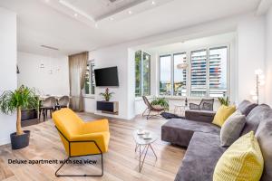 a living room with a gray couch and yellow chairs at Apartments Liana in Opatija