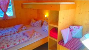 a bedroom with a bunk bed with pink pillows at Zirkuswagen in Holzminden