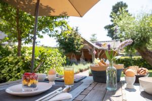 un tavolo da picnic con cibo e bevande e un ombrello di Bed & Breakfast Monument076 Etten-Leur a Etten-Leur